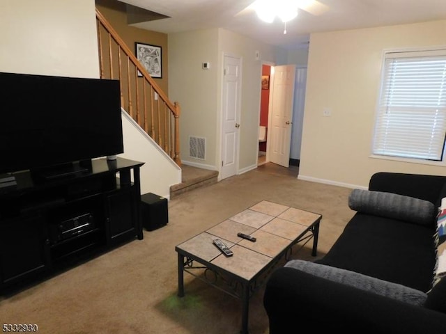 living room featuring stairway, a ceiling fan, carpet, visible vents, and baseboards