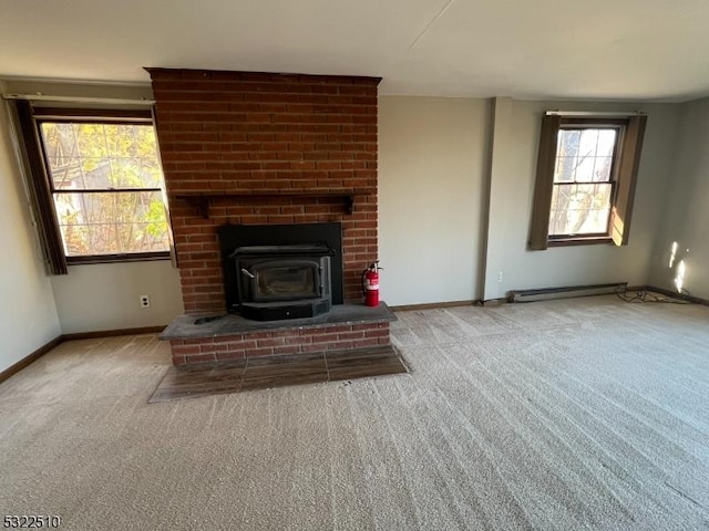 unfurnished living room with a wood stove, baseboard heating, and light colored carpet