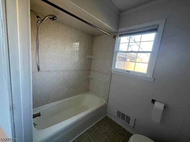 bathroom featuring tiled shower / bath combo, crown molding, toilet, and tile patterned flooring