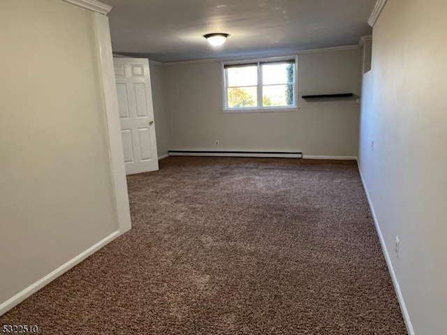 spare room featuring a baseboard radiator, dark carpet, and crown molding