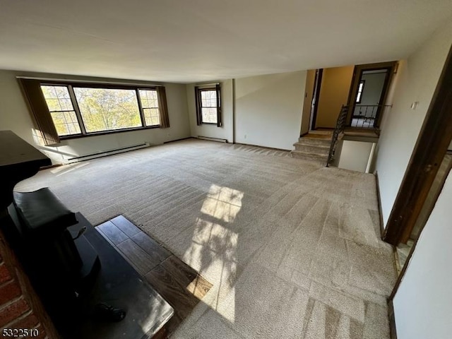 unfurnished living room featuring baseboard heating and carpet flooring