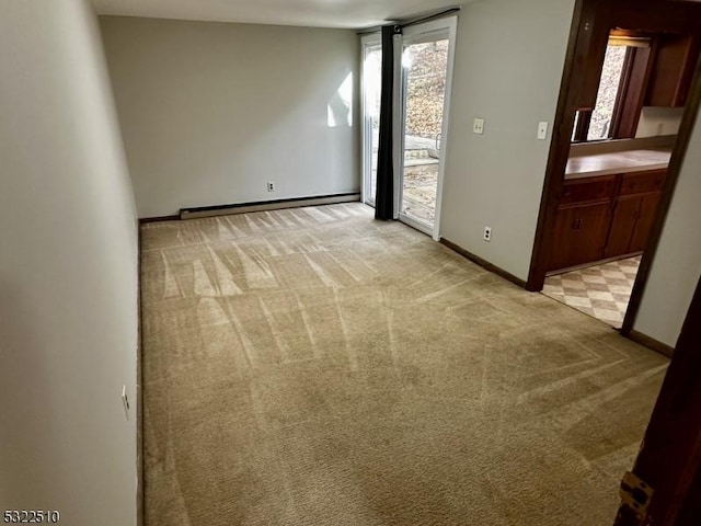 carpeted empty room featuring a baseboard radiator