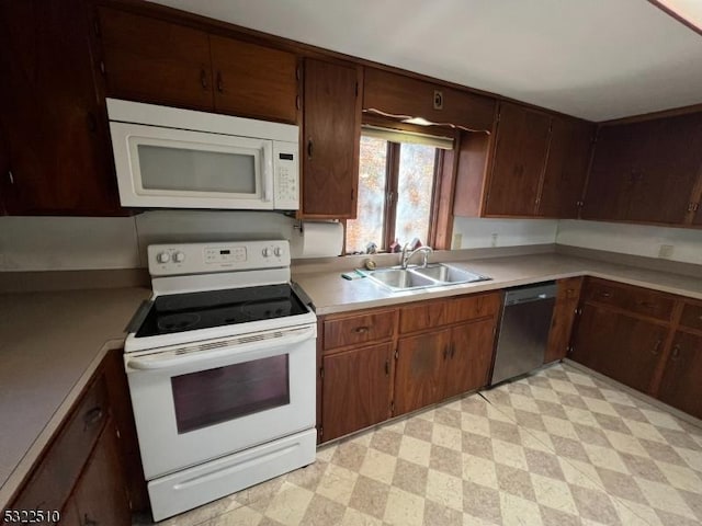 kitchen featuring sink, white appliances, and dark brown cabinetry