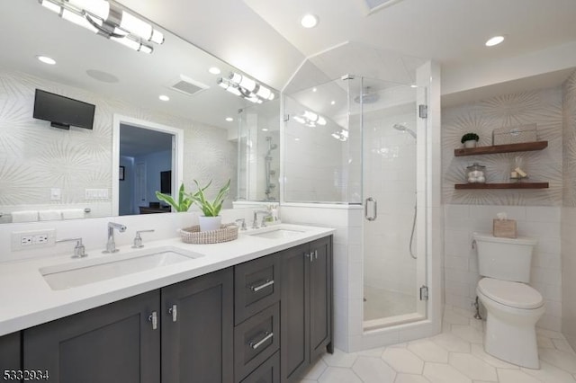 bathroom featuring toilet, vanity, tile patterned flooring, tile walls, and an enclosed shower