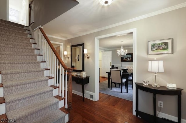 stairs featuring an inviting chandelier, ornamental molding, and hardwood / wood-style floors