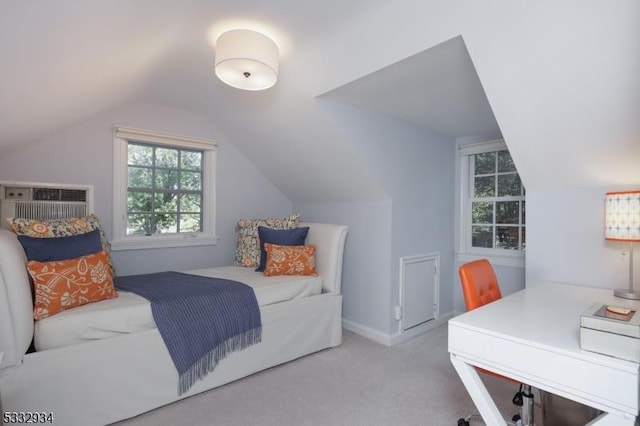 bedroom featuring vaulted ceiling, light colored carpet, and an AC wall unit