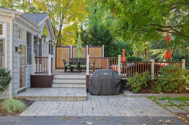 view of patio featuring a wooden deck and a grill