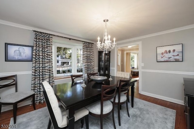 dining room with dark hardwood / wood-style flooring, crown molding, and a chandelier