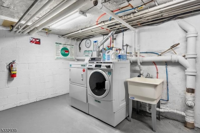 clothes washing area featuring sink and independent washer and dryer