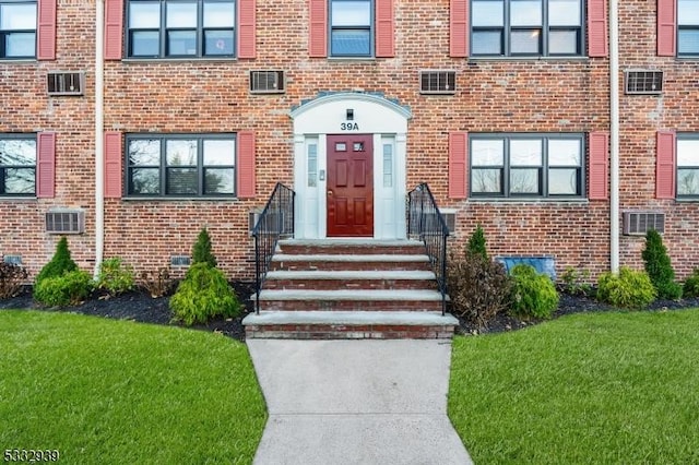 view of exterior entry with a lawn