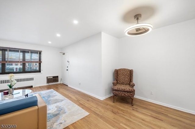 sitting room featuring light hardwood / wood-style flooring, heating unit, and radiator