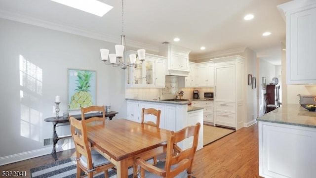 dining room featuring dark hardwood / wood-style flooring, a chandelier, and ornamental molding