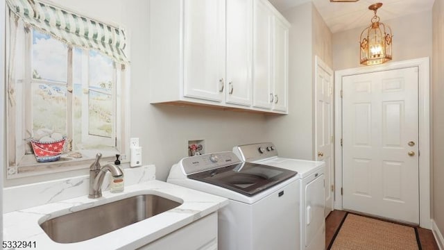 laundry area featuring washing machine and dryer, sink, and cabinets