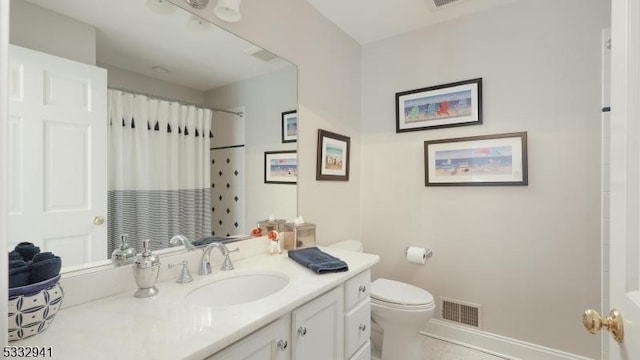 bathroom featuring toilet, tile patterned floors, vanity, and curtained shower