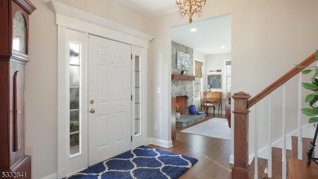 foyer featuring a fireplace, dark hardwood / wood-style floors, and a chandelier