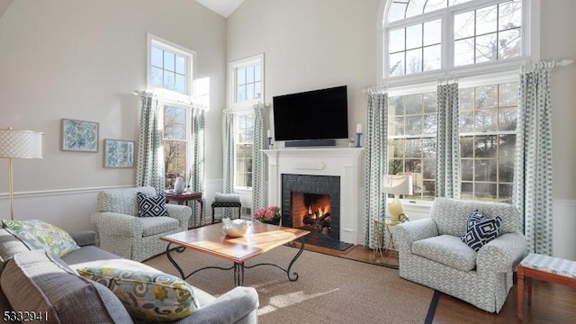 living room with plenty of natural light, a fireplace, and a high ceiling