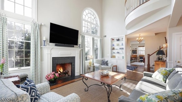 living room with a notable chandelier, a high ceiling, and hardwood / wood-style flooring