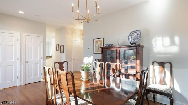 dining room with hardwood / wood-style flooring and an inviting chandelier