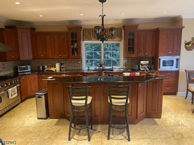 kitchen with stainless steel appliances, a kitchen island with sink, pendant lighting, and a chandelier