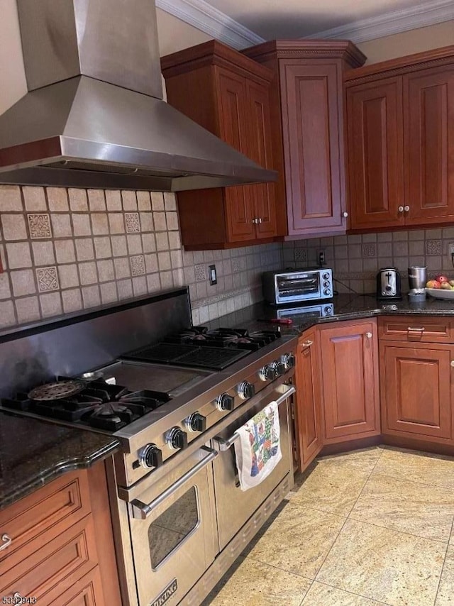 kitchen with decorative backsplash, ornamental molding, range with two ovens, and wall chimney exhaust hood