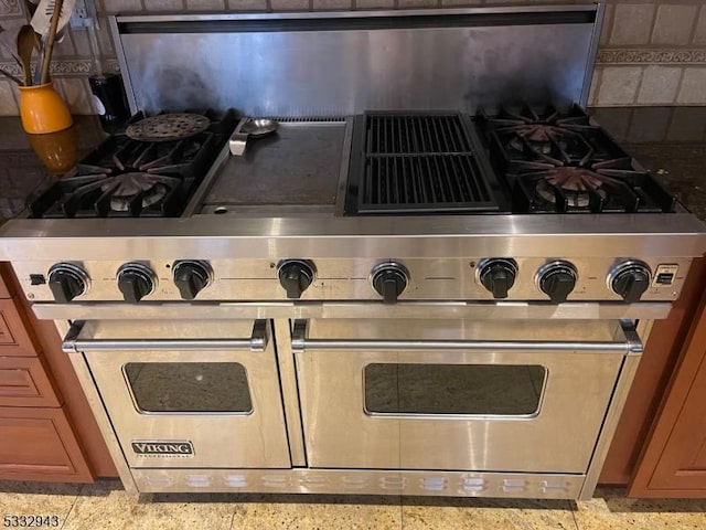 interior details featuring range with two ovens and stone counters