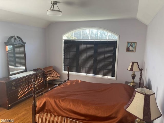 bedroom featuring light wood-type flooring and lofted ceiling