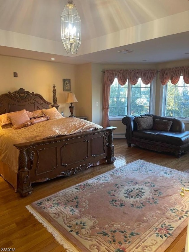 bedroom with dark wood-type flooring and an inviting chandelier