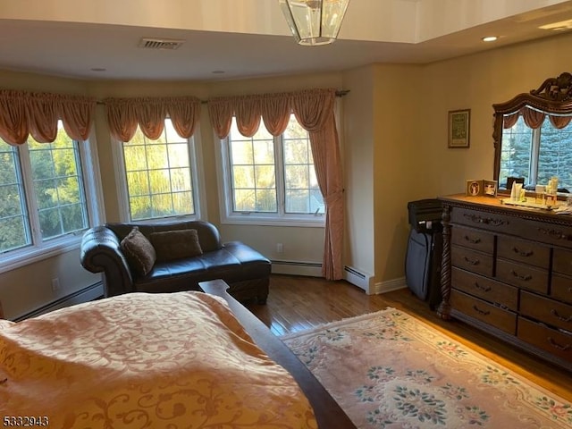 sitting room with hardwood / wood-style floors and a baseboard heating unit