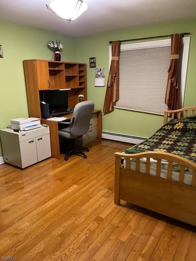 bedroom featuring light hardwood / wood-style floors and a baseboard heating unit
