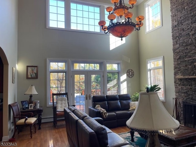 living room with a towering ceiling, a fireplace, and a chandelier