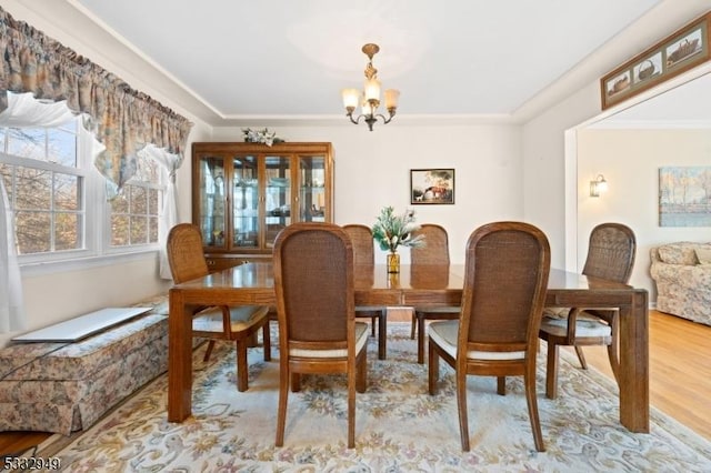 dining space featuring light wood-type flooring and a chandelier