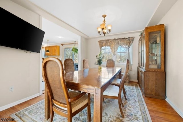 dining space featuring light hardwood / wood-style flooring and a notable chandelier