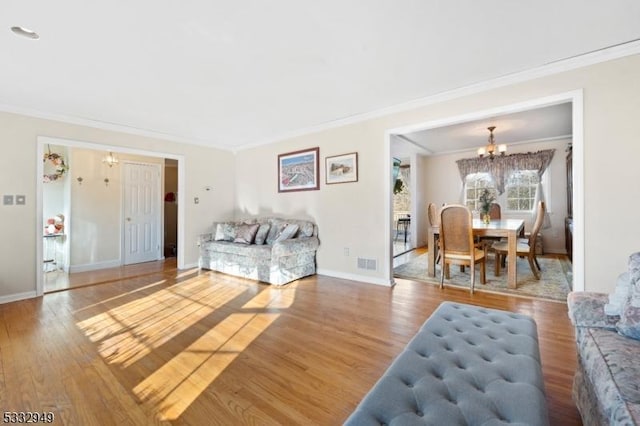 living room featuring a notable chandelier, crown molding, and hardwood / wood-style floors