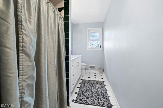 bathroom with toilet, vanity, and curtained shower