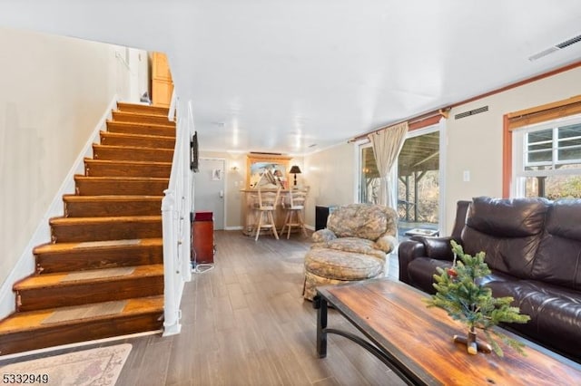 living room featuring hardwood / wood-style floors and crown molding