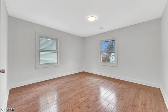 spare room with hardwood / wood-style flooring and a healthy amount of sunlight