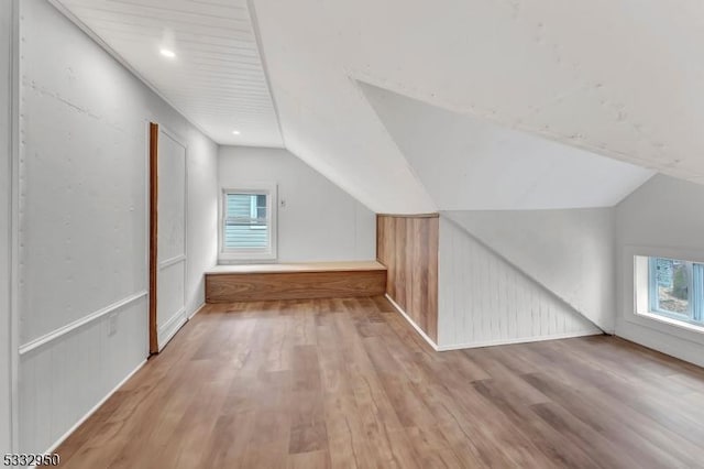 bonus room with vaulted ceiling and light hardwood / wood-style flooring