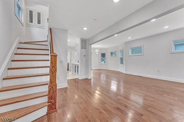 stairs with an inviting chandelier and wood-type flooring