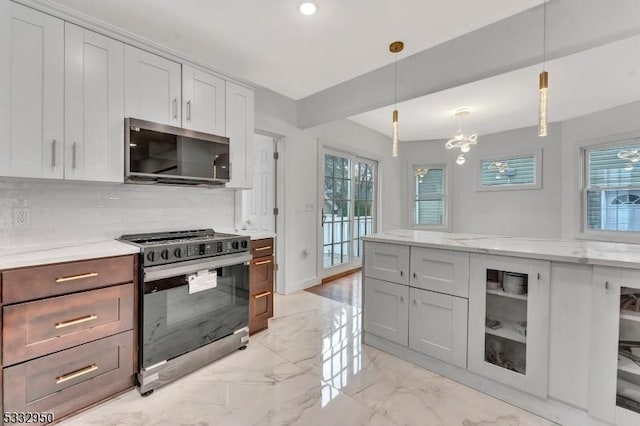 kitchen featuring light stone counters, decorative light fixtures, tasteful backsplash, stainless steel gas stove, and plenty of natural light