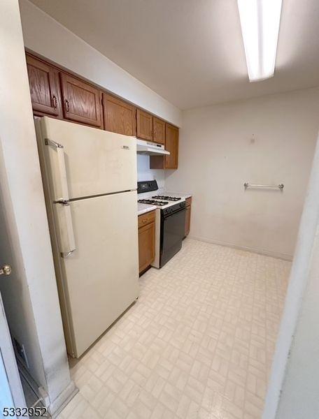 kitchen with white refrigerator and range with gas cooktop