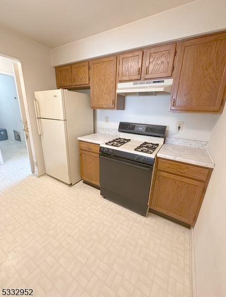 kitchen with white refrigerator and gas range