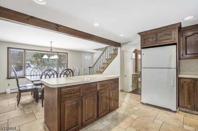 kitchen with pendant lighting, dark brown cabinetry, a kitchen island, beamed ceiling, and white fridge