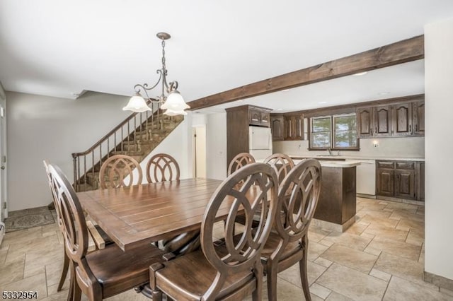 dining area featuring sink, a chandelier, and beam ceiling