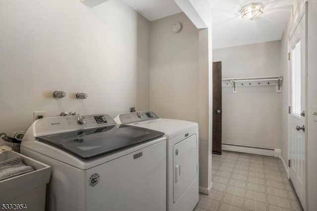 clothes washing area with baseboard heating, washer and clothes dryer, and sink