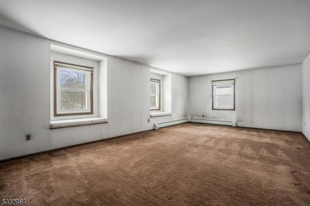 unfurnished room featuring a baseboard heating unit and carpet