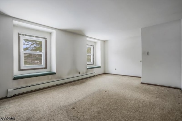 empty room featuring a baseboard radiator and light carpet