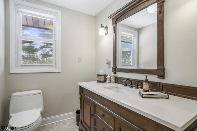 bathroom featuring a wealth of natural light, toilet, and vanity