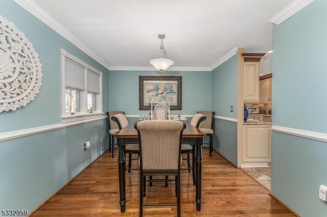 dining space featuring hardwood / wood-style floors and crown molding