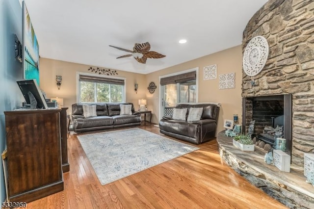 living room with ceiling fan, a fireplace, and hardwood / wood-style flooring