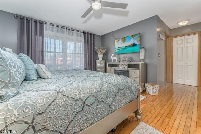 bedroom with ceiling fan, a closet, and hardwood / wood-style flooring